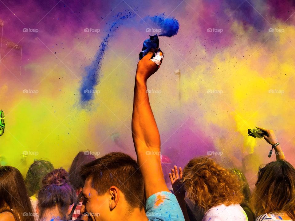 Group of people celebrating with multi colored powder