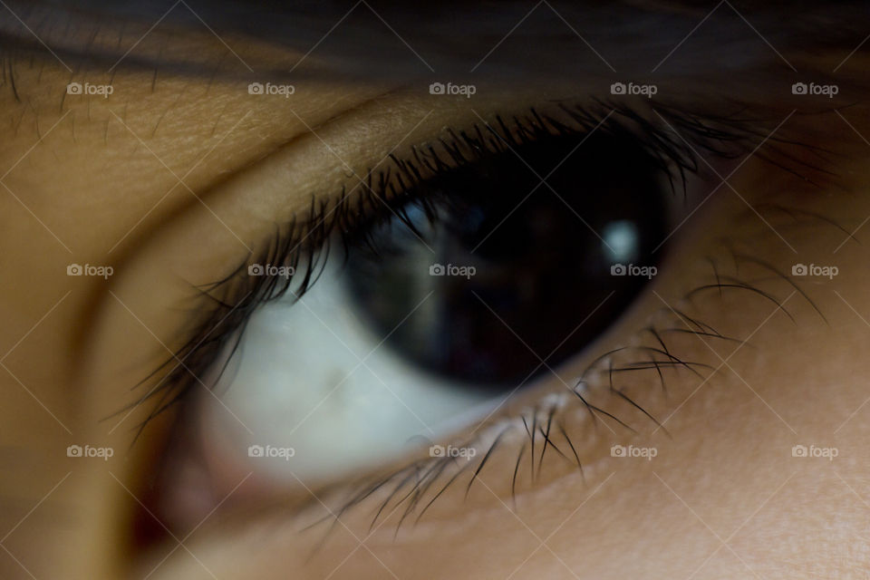 macro close up of deep black eye almond shape of a young Asian boy