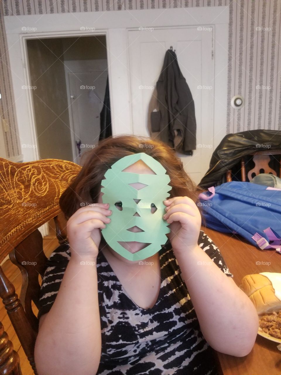 A girl crafting and artsy mask.