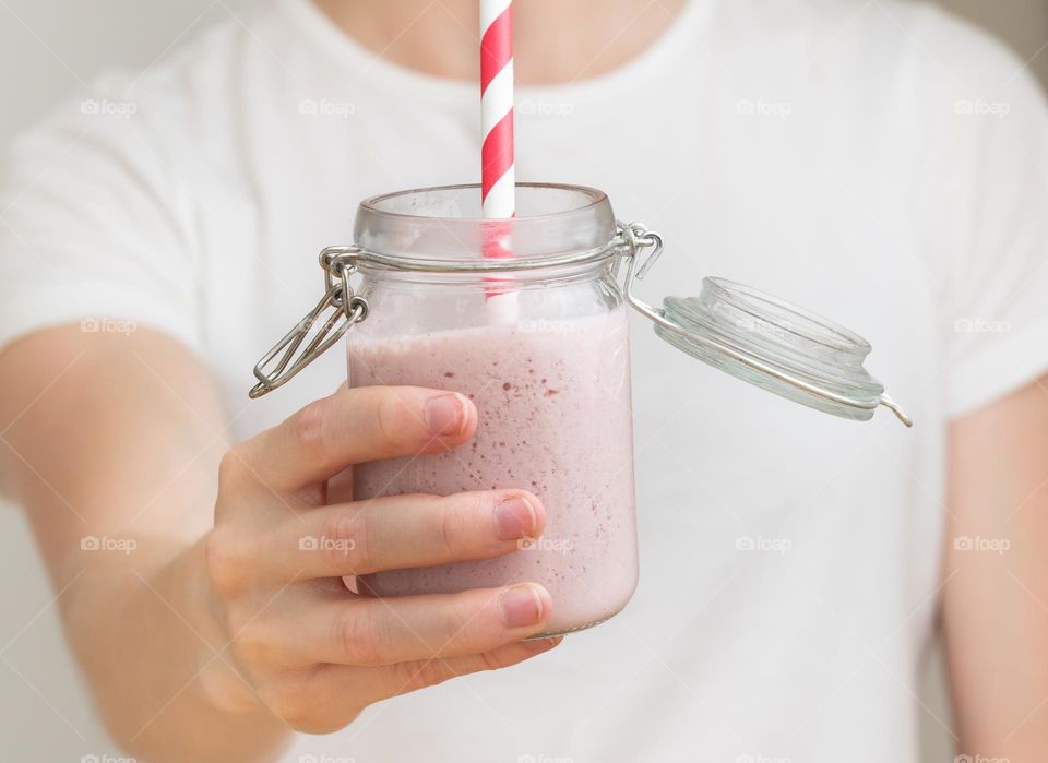 Woman holding strawberry milkshake