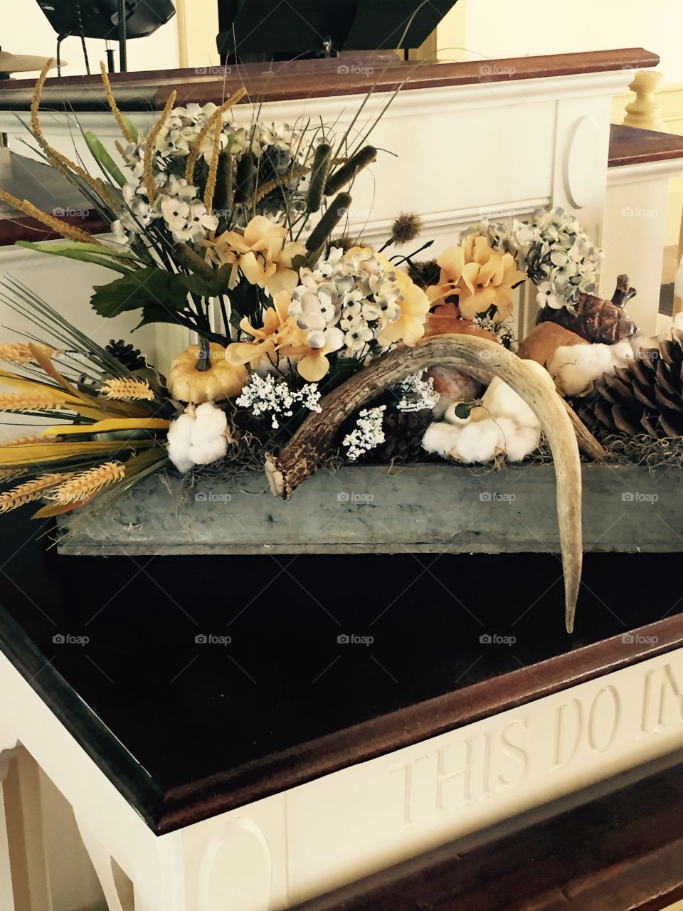Fall decorations in muted colors, with flowers,deer horns, baby's breath. 
