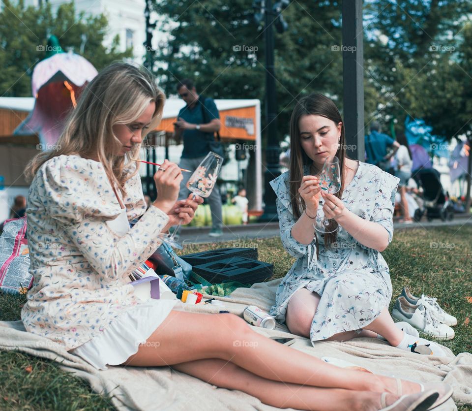 Girls paint glass dishes with special paint