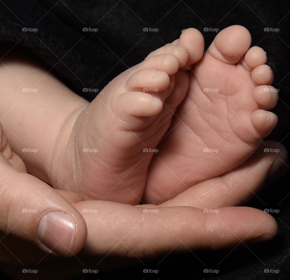 Father holding infants feet