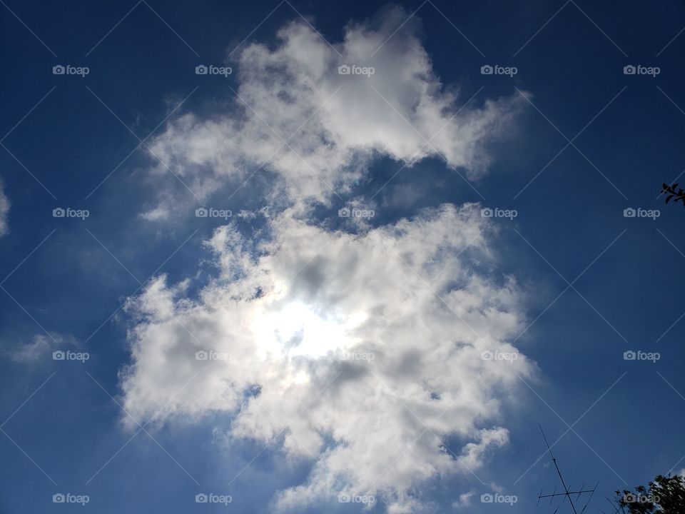 sun behind clouds in the sky