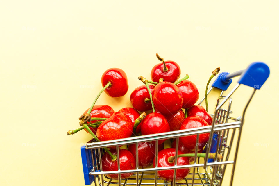 Fresh cherries lying in mini grocery cart