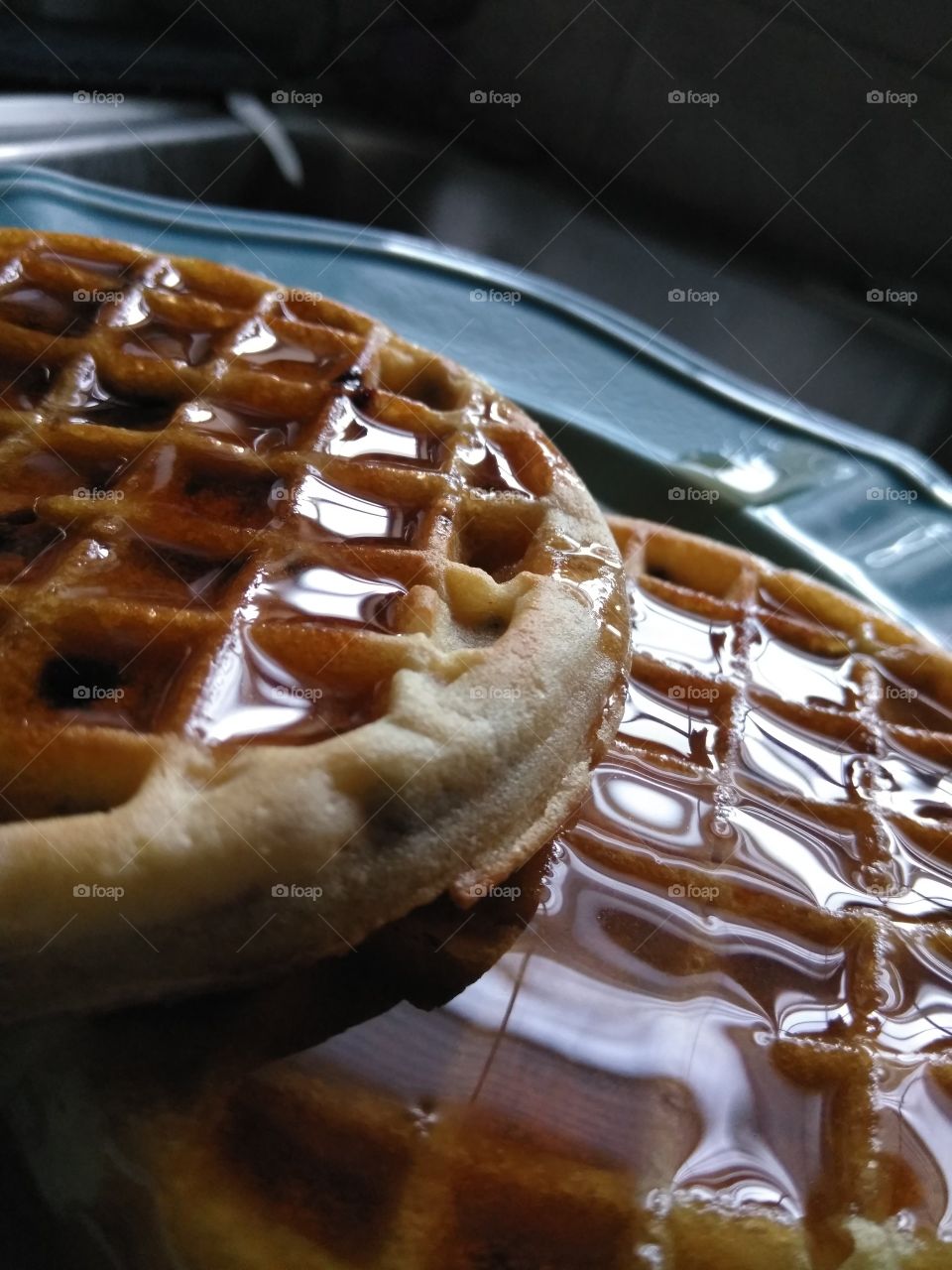Two waffles drenched in glistening syrup