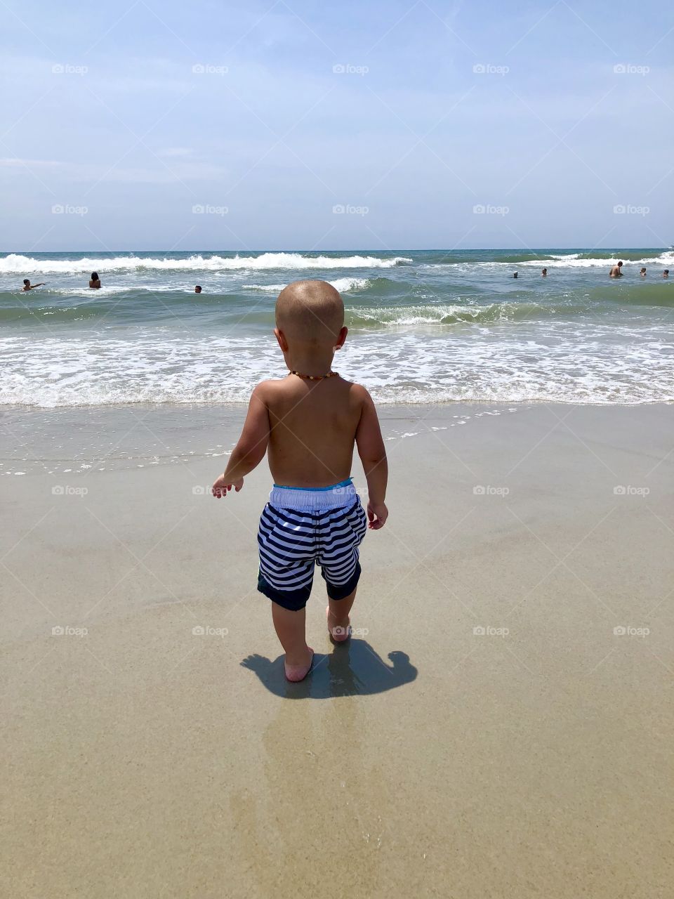 Toddler studying the ocean waves
