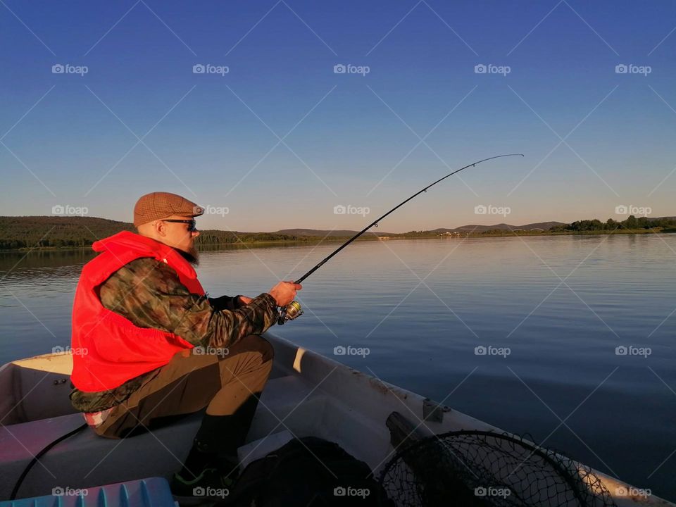 a man fishing in Finnish Lapland on a summer night