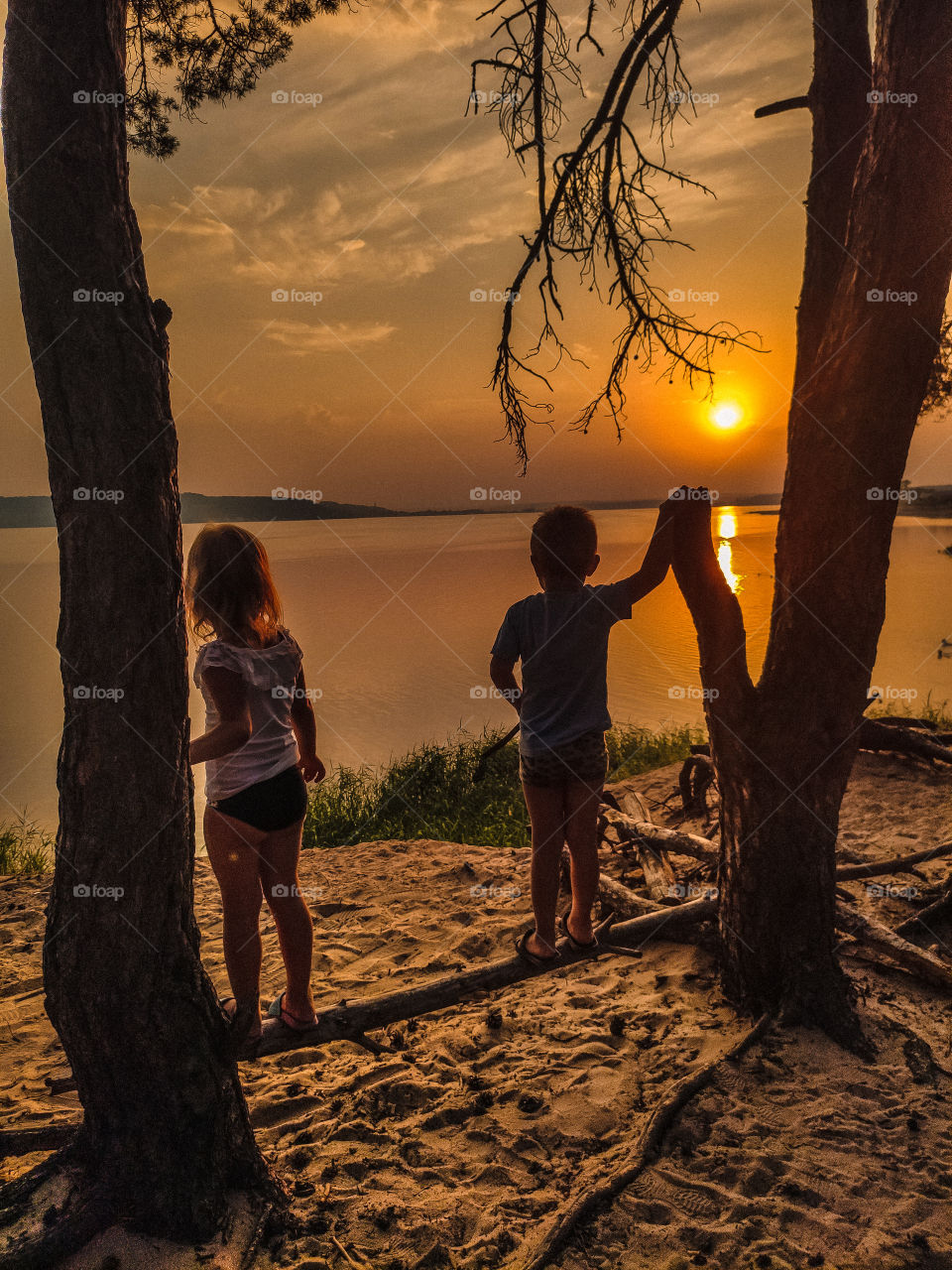 children watching the sunset on the river