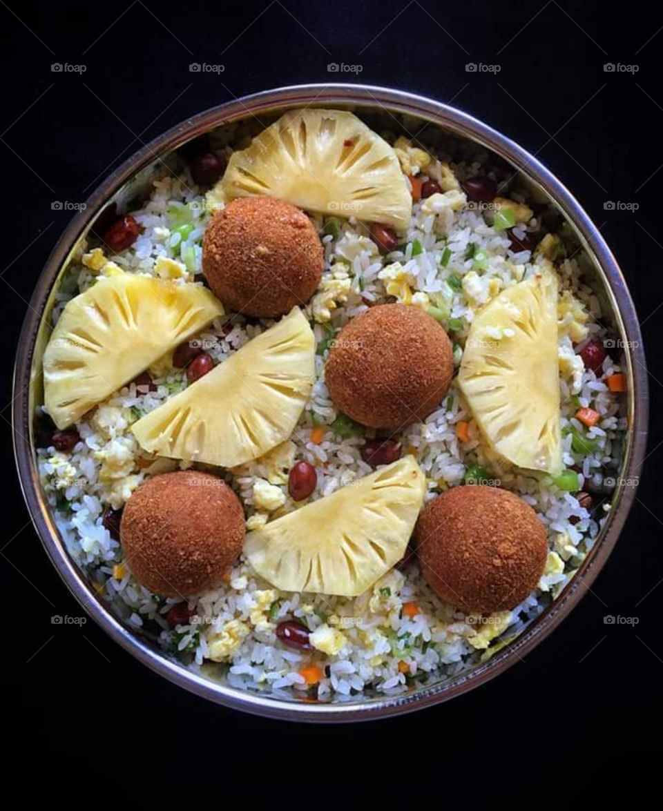 Vegetable rice with fish cutlets and pineapple .