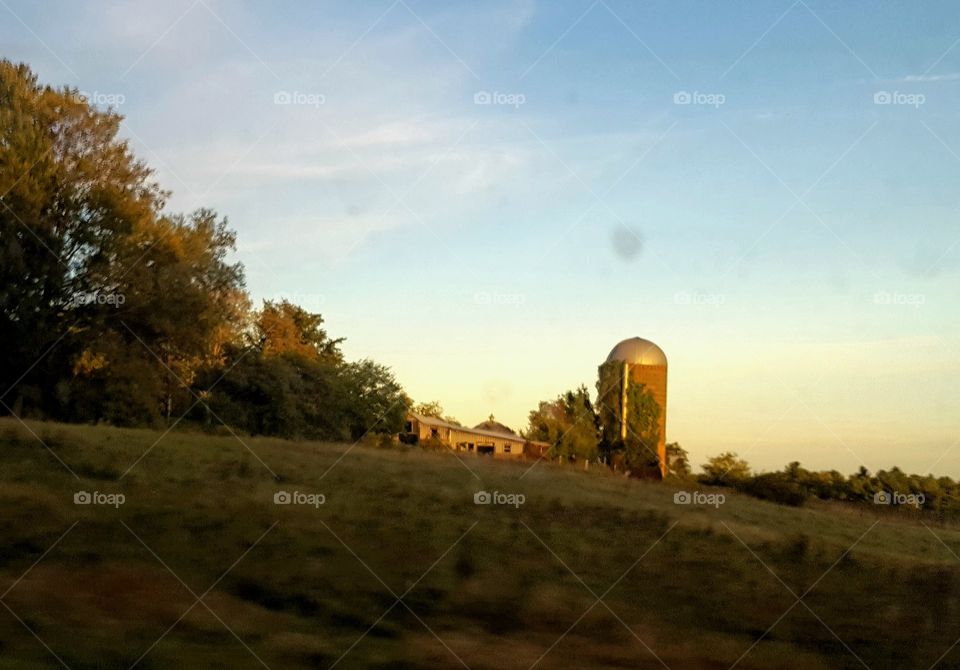 landscape of farm and silo at sunset