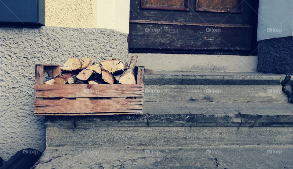 Pieces of wood in the wooden corb on the porch. Free space for a text
