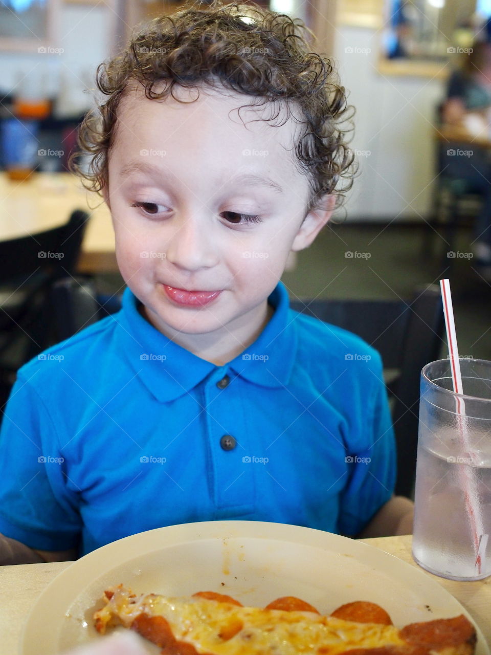 A little boy feeling content after finishing off his favorite snack. 