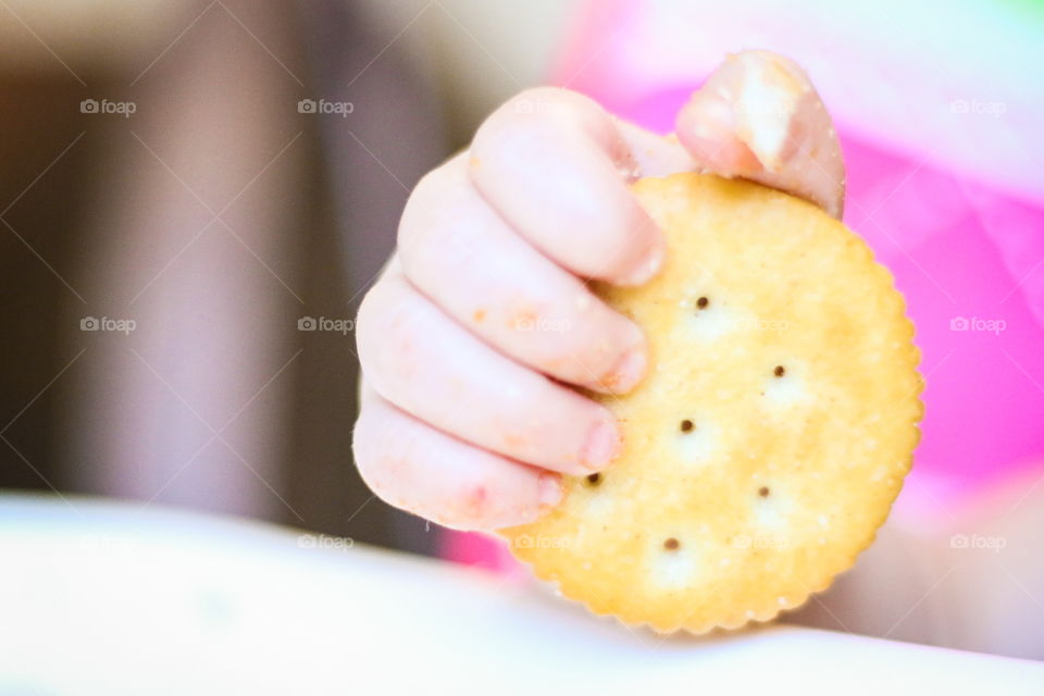 Baby hand clutching cracker 