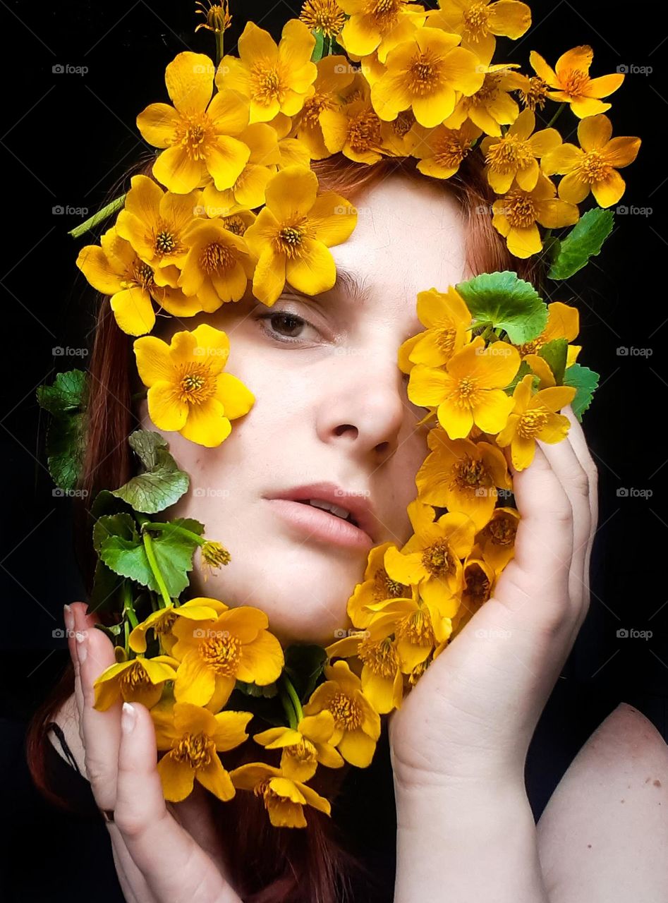 an original portrait of a girl with spring yellow flowers near her face