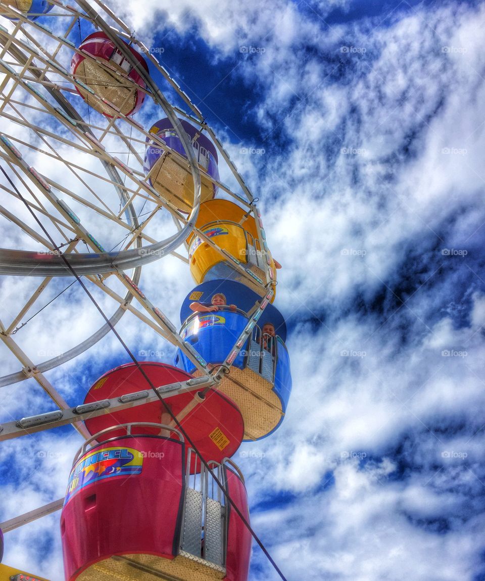 Close-up of ferris wheel against cloudy sky