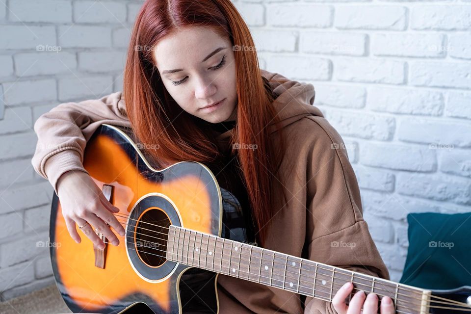 teen girl playing guitar