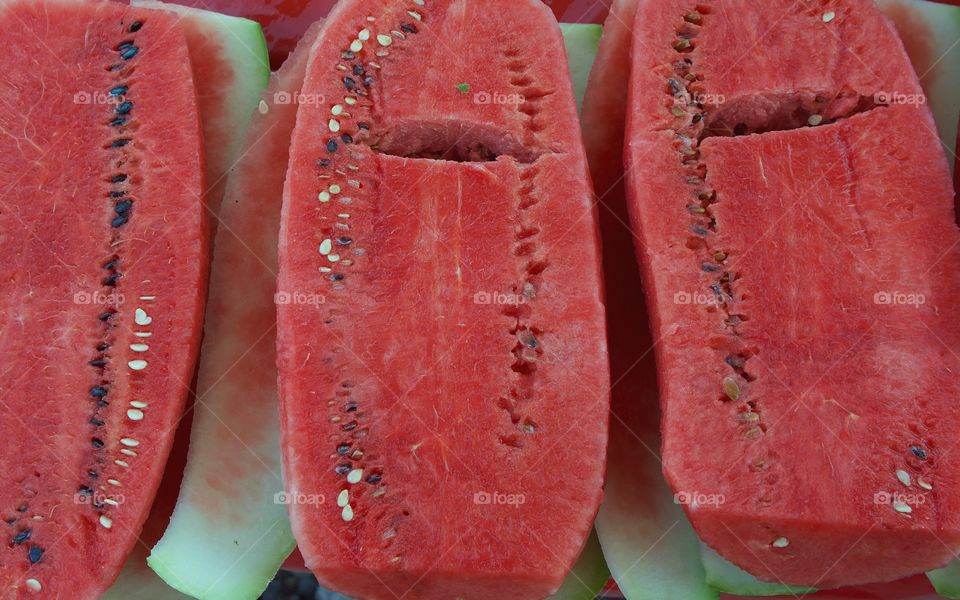 A closeup of large cut open watermelons for sale at an outside market in San Miguel de Allende , Mexico.