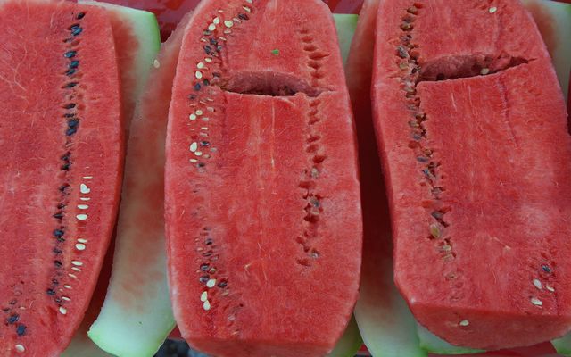 A closeup of large cut open watermelons for sale at an outside market in San Miguel de Allende , Mexico.