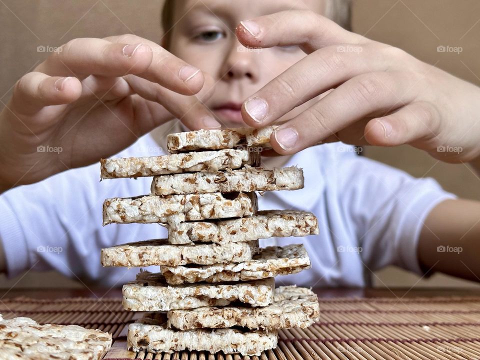 child folds a pyramid of square slides