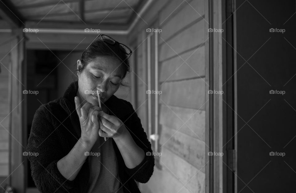 A black and white picture of a lady doing her nails.