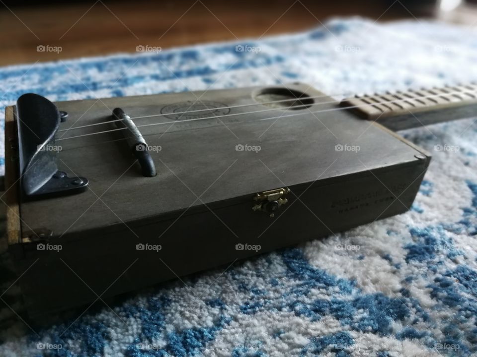 Cigar box guitar on blue background