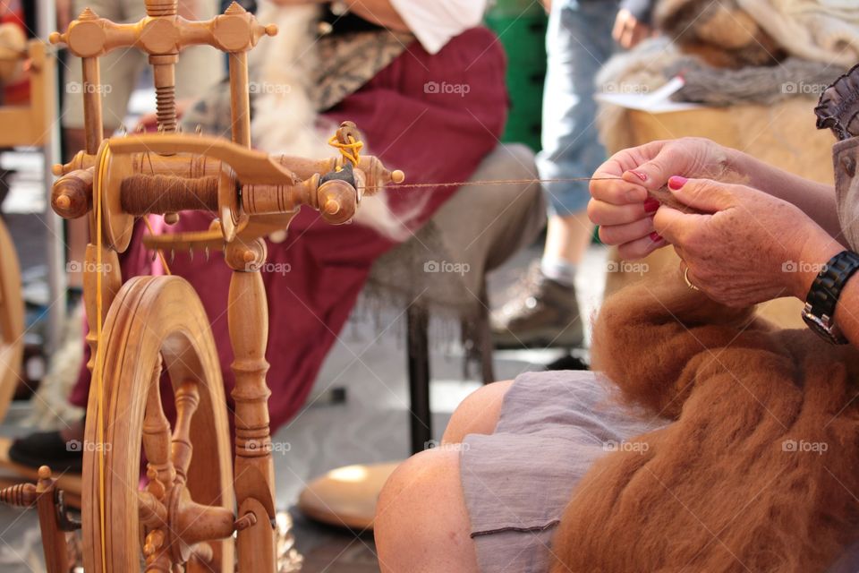 Woman spinning wheel to make yarn