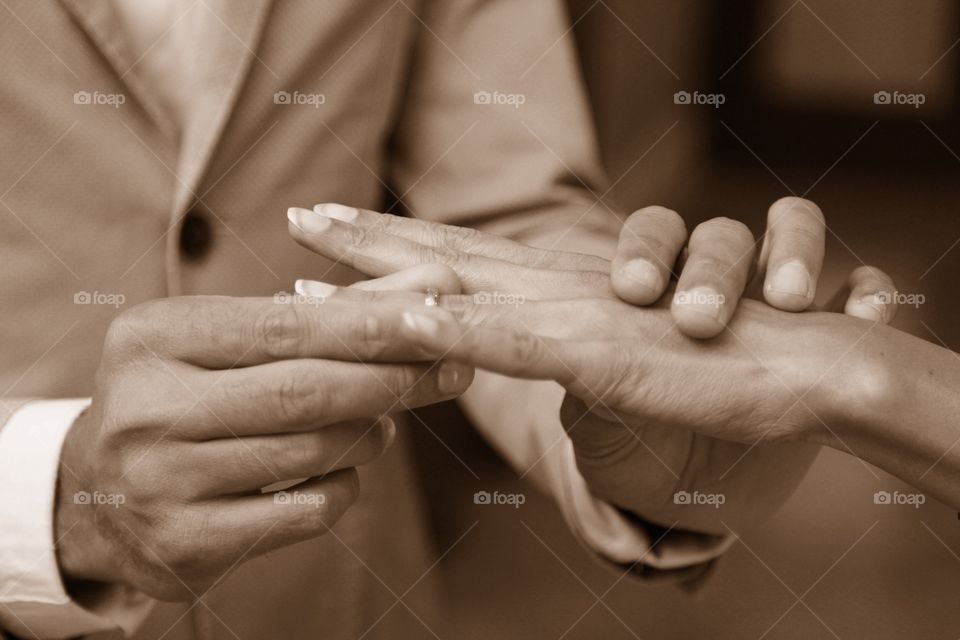 Groom putting ring onto brides finger