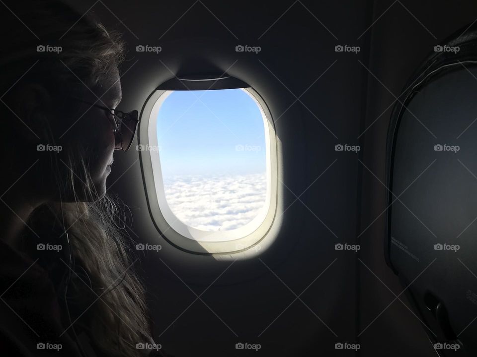 Beautiful girl looking out plane window