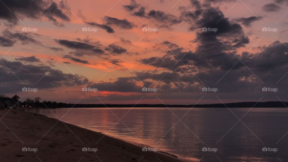 Pink sunset on the calm beach. 