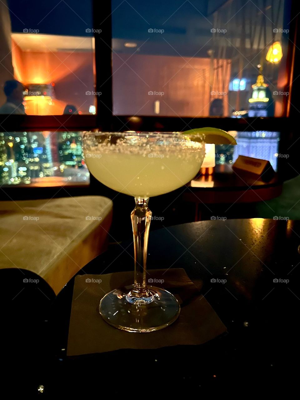На фотографии изображен элегантный бокал с мартини, его стекло прозрачное и идеально чистое, отражая свет, создавая игру оттенков.
