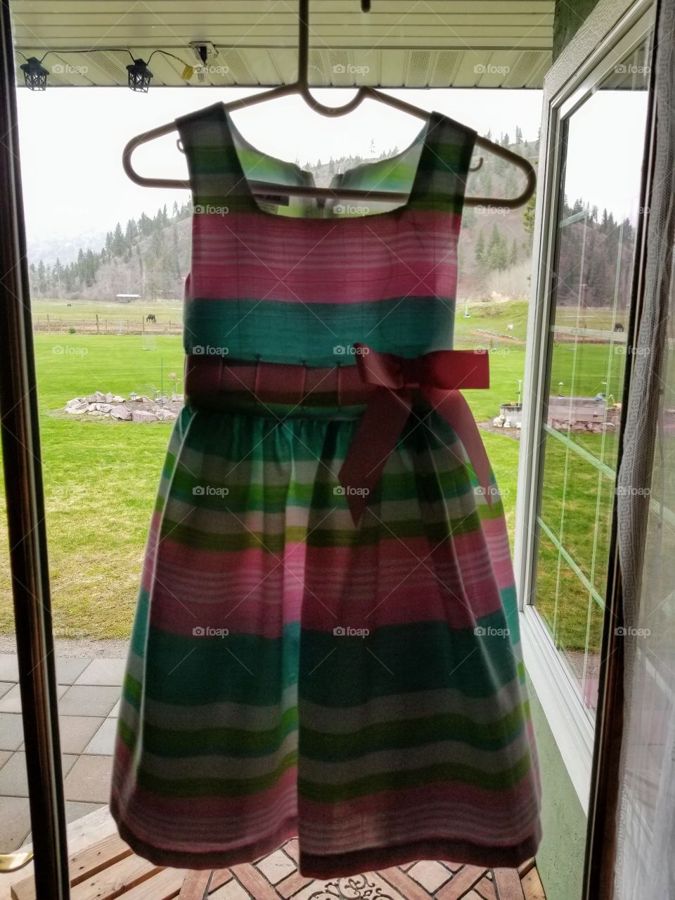 spring Easter dress hangs ready for little girl to wake up. green grass means spring is here