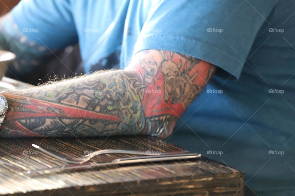 Man with colourful tattoo on his forearm 