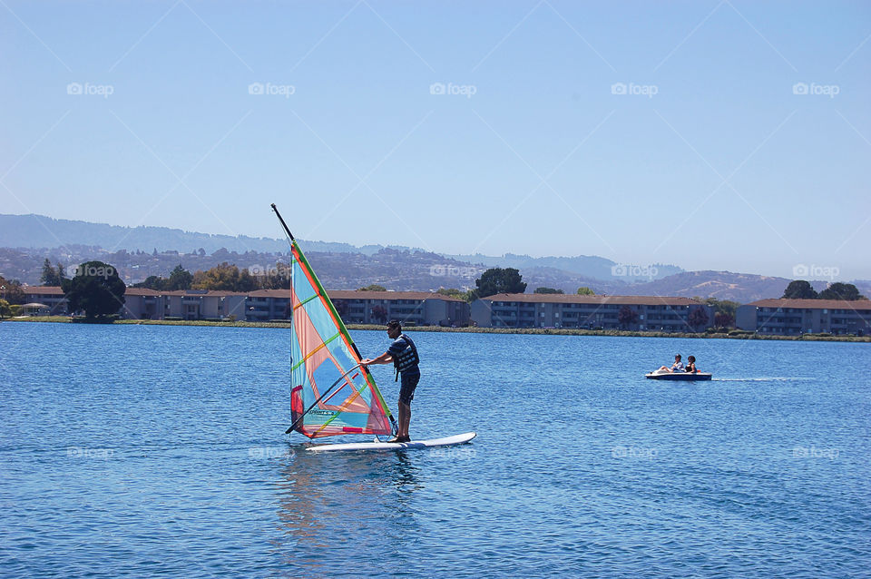Guided by the wind. Guided by the wind, the windsurfer enjoys a bright summer day in the blue lagoons of California