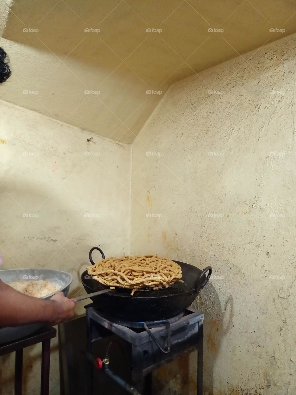 a worker making chakli it's tasti snacks