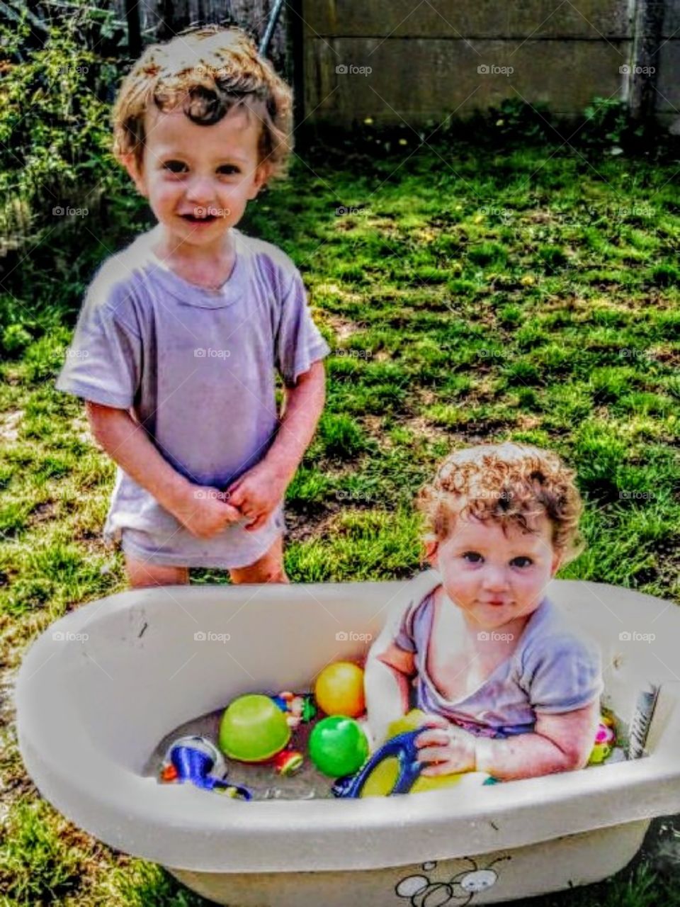My children playing in the garden in the  summer with water