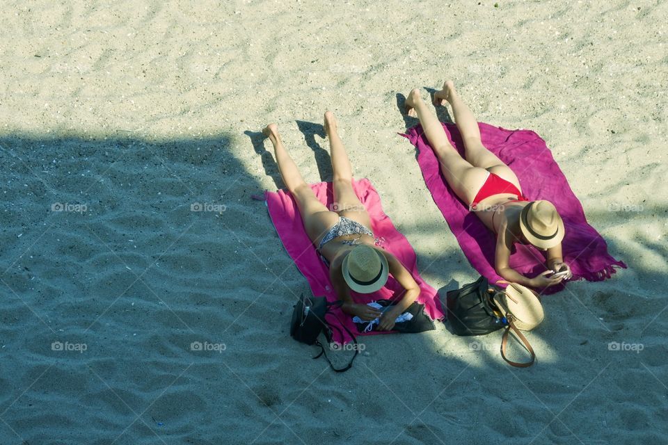 Moods of summer. Top view of two girls sunbathing 