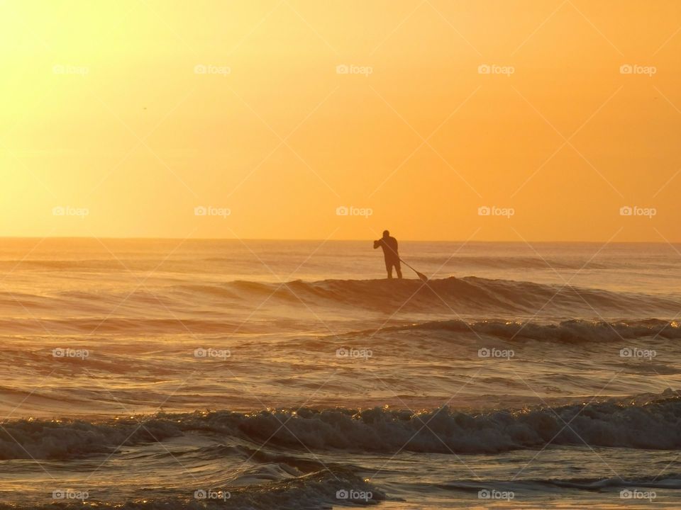 surfing on the beach, sunrise