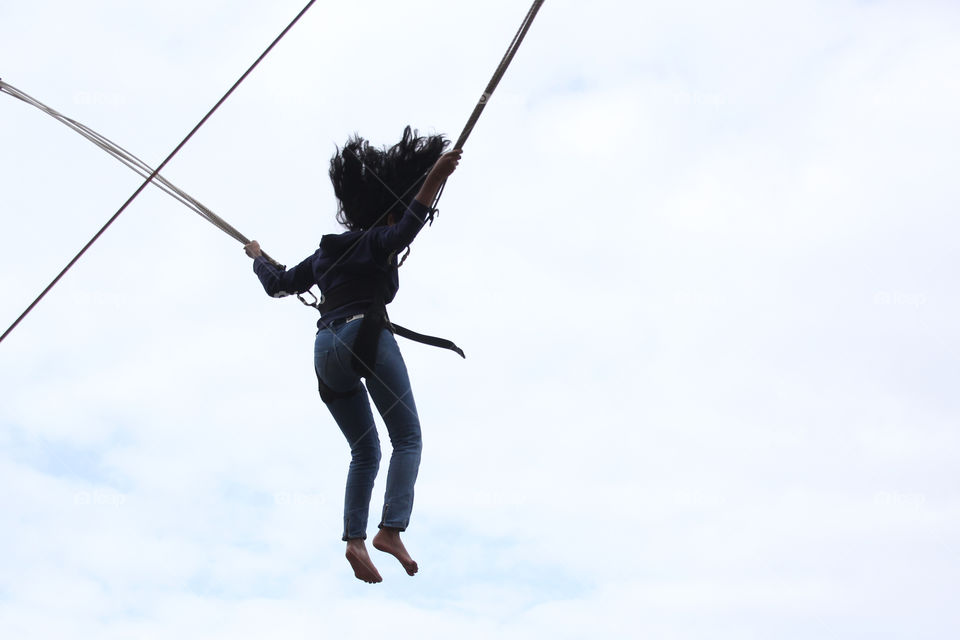 Girl jumping on bungee trampoline, fun times