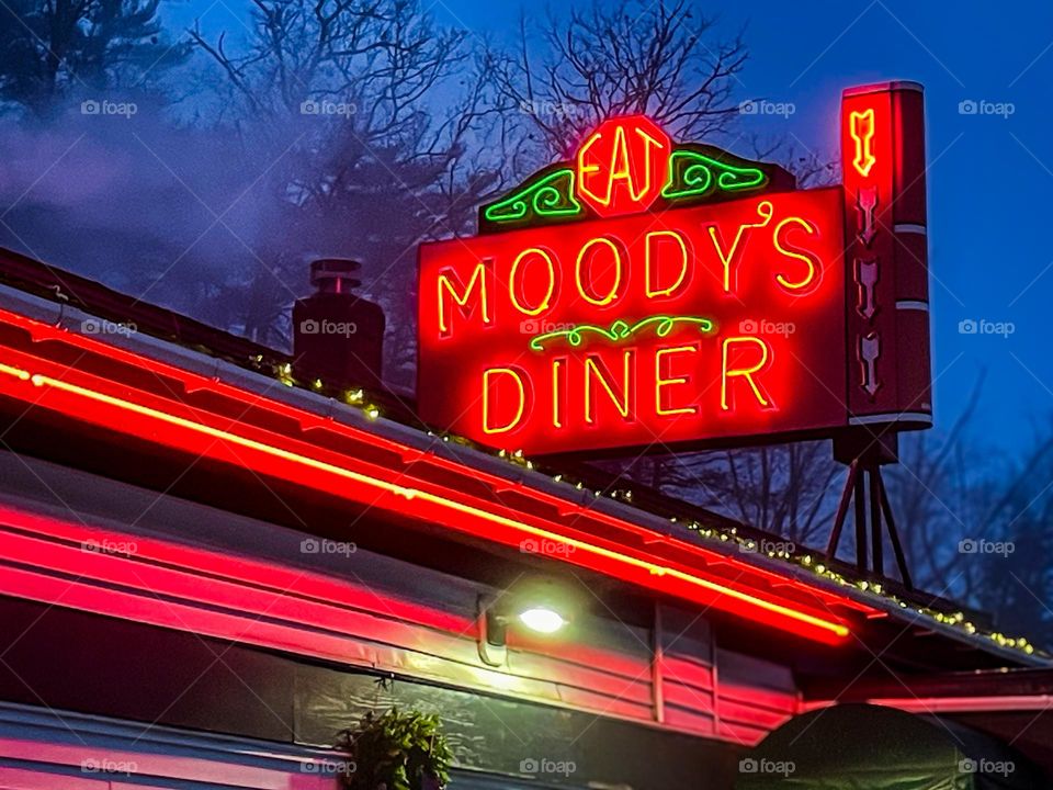 Neon lights shine like a beacon in the night at a vintage diner.