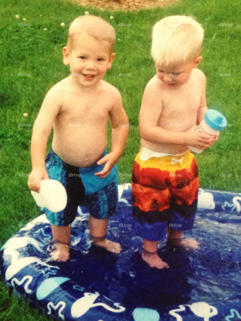 2 boys standing in water 