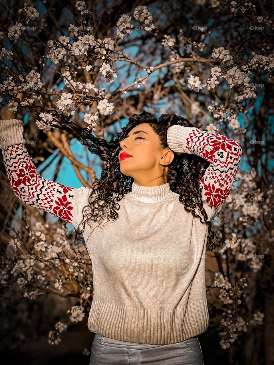 Curly-haired girl and blossoms in the spring air