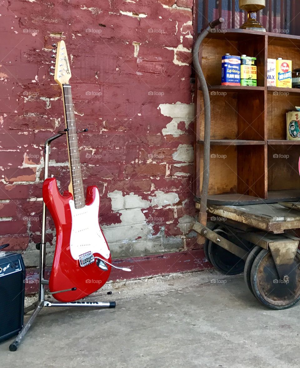 Red Guitar by Red Brick Wall