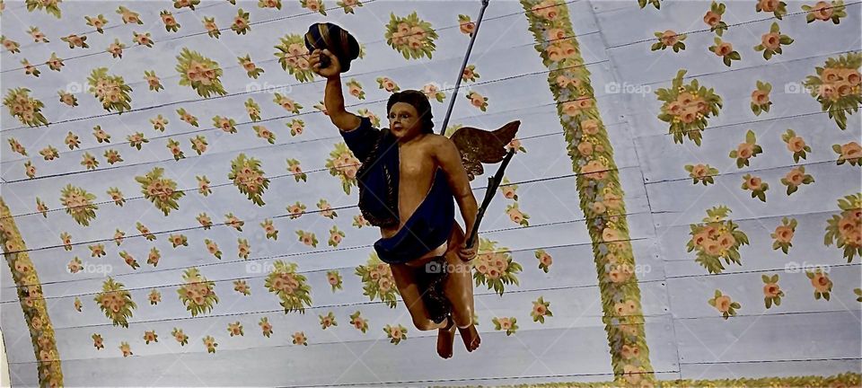 This is the “Taufengel”, a baptismal angel hanging from the ceiling of the “Inselkirche”, the “Island Church” on the island “Hiddensee” in the town of “Kloster” surrounding a former protestant cloister built in 1300. 2024. Hypnotic Productions