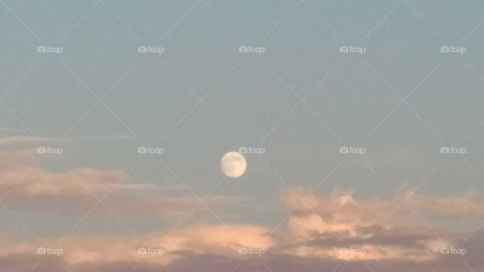 Full moon over cloudy Montana sunset