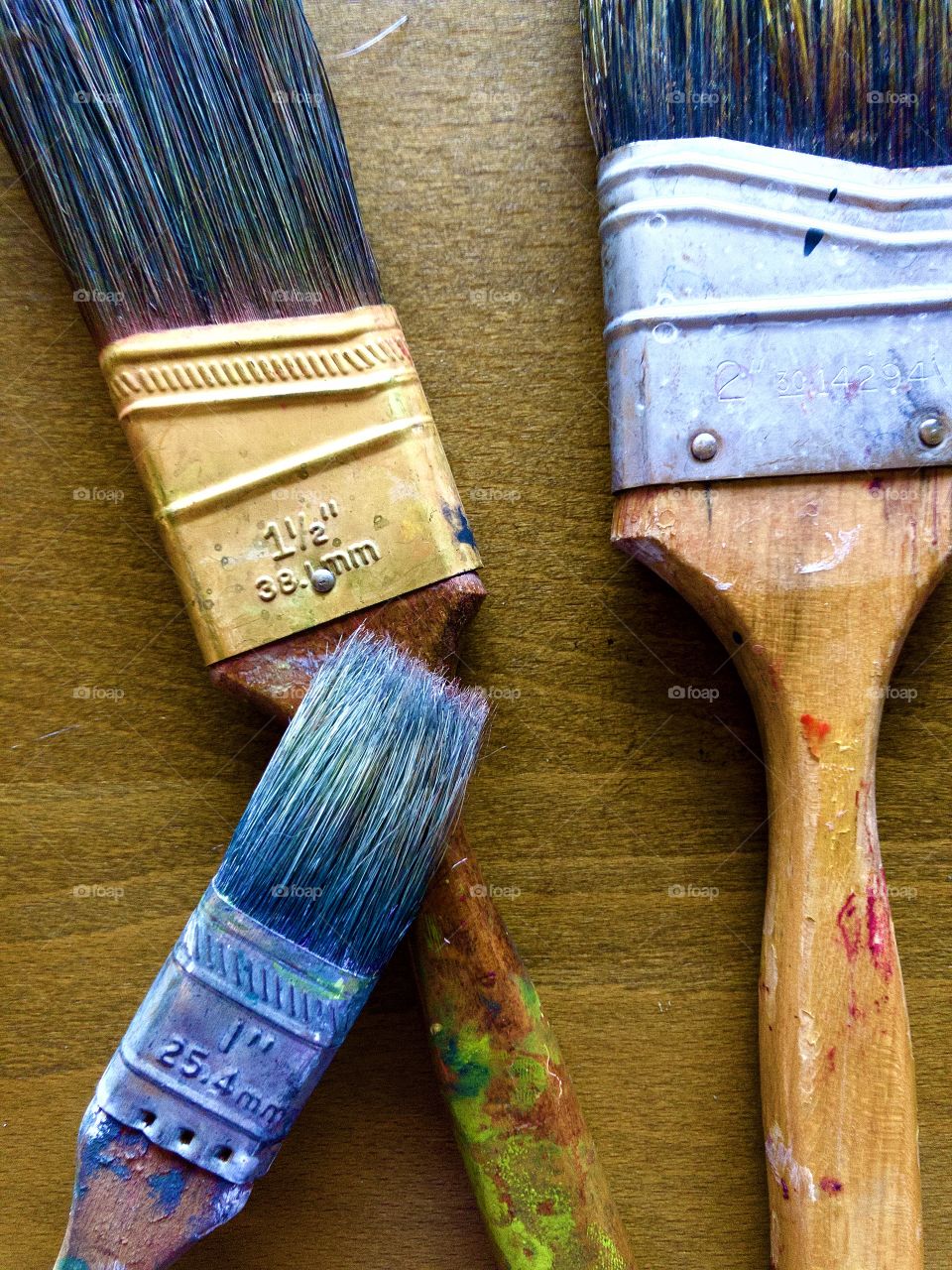 Overhead closeup of used paintbrushes on desk 