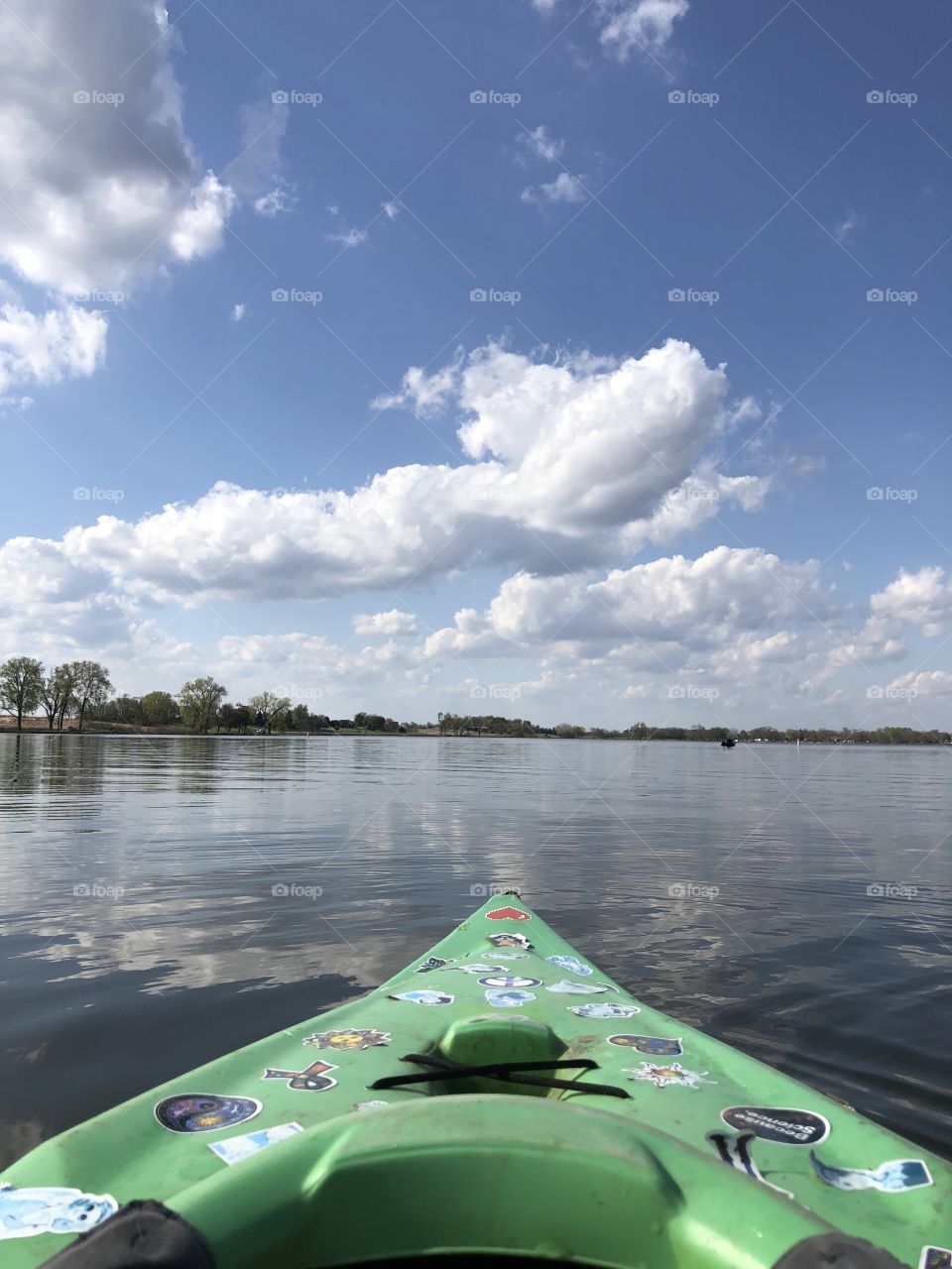 Kayaking past fluffy clouds on the open lake 