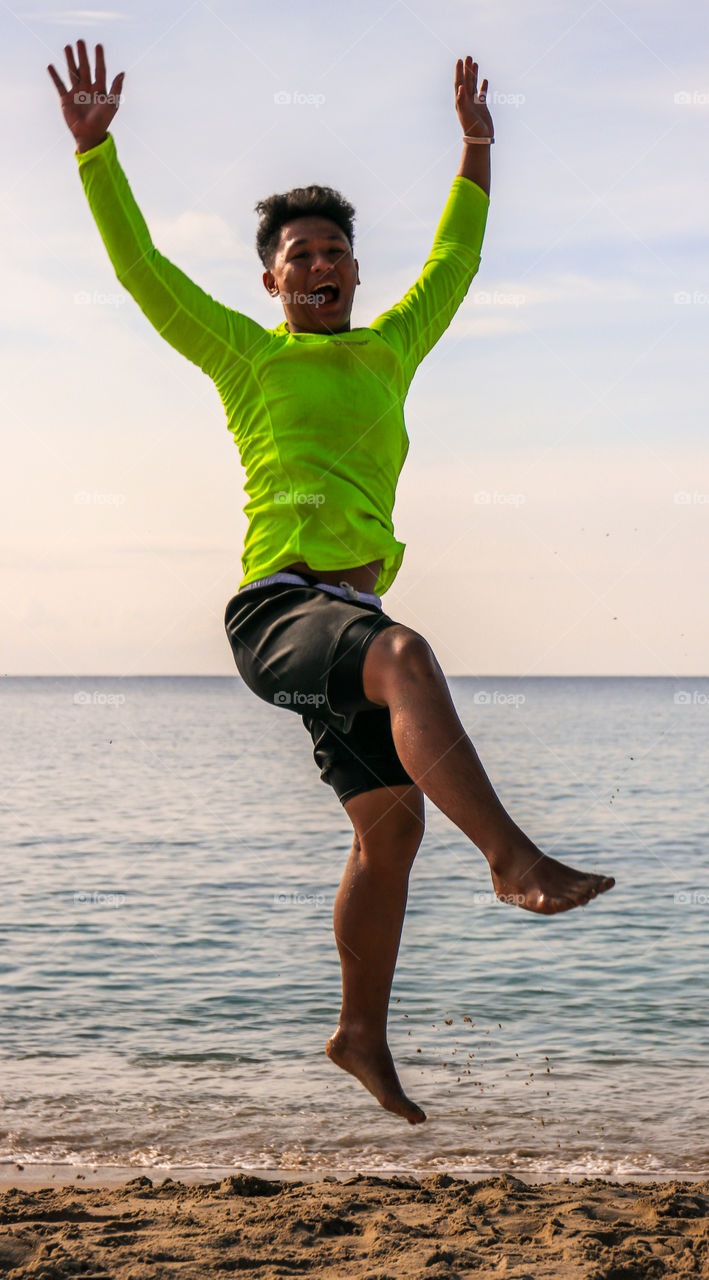 A Young Man Jumped  over his Excitement while on a Summer Vacation at the Beach...