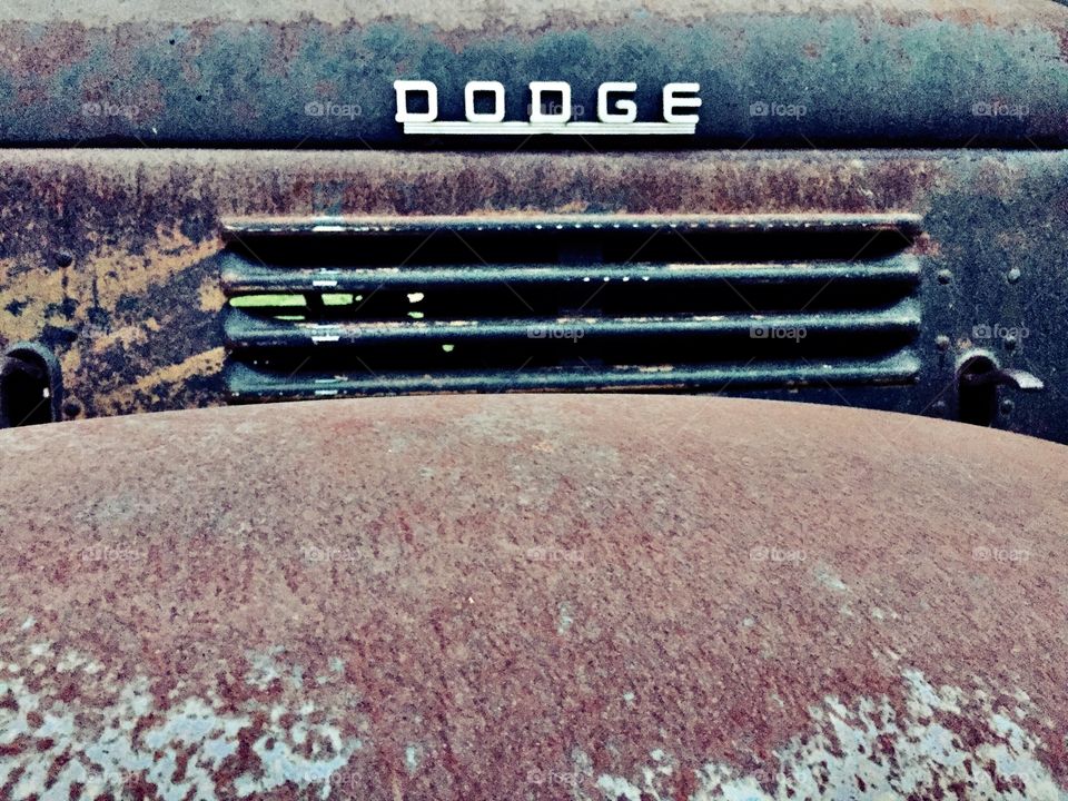 Isolated view of engine vents and right front fender with Dodge logo on a rusty vintage farm truck