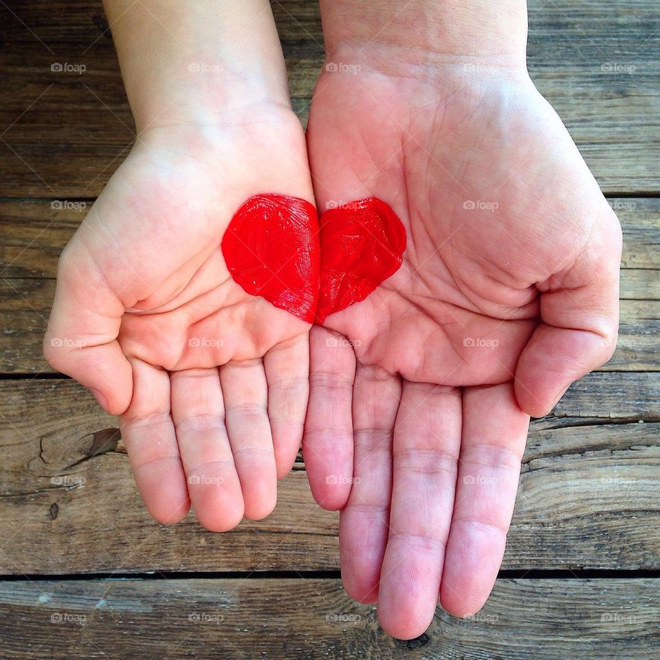 High angle view of person's hand forming red heart shape